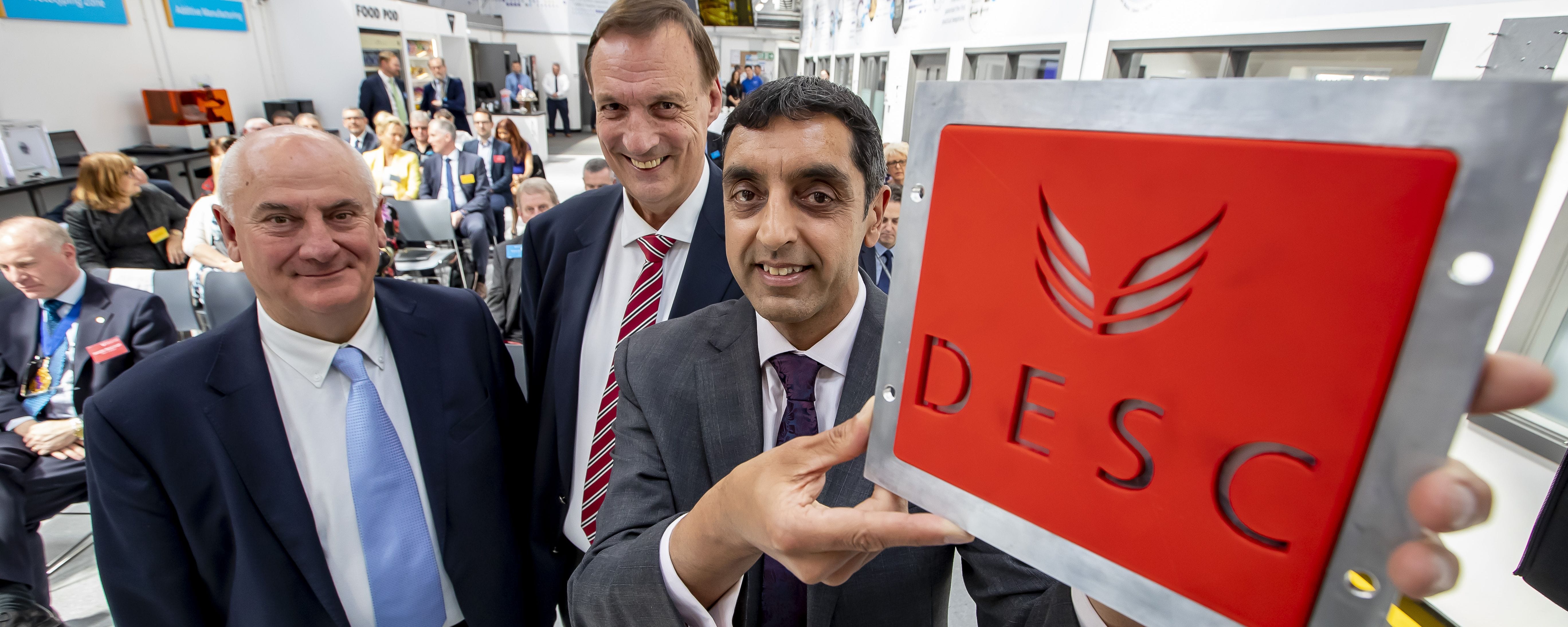 principal holds £D printed DESC sign with Corporation Chair and LEP Chair facing