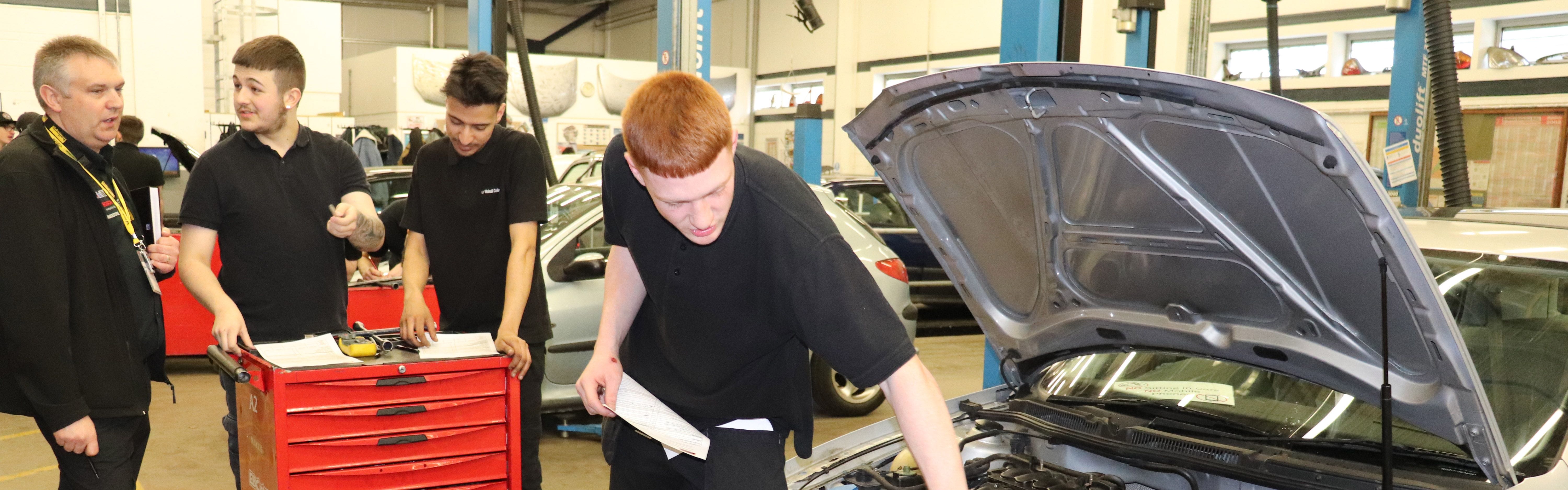 male automotive students speaking with Halfords representative