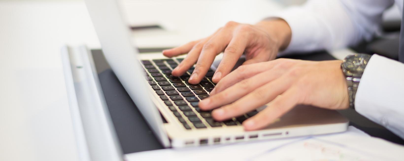 A person typing on a laptop