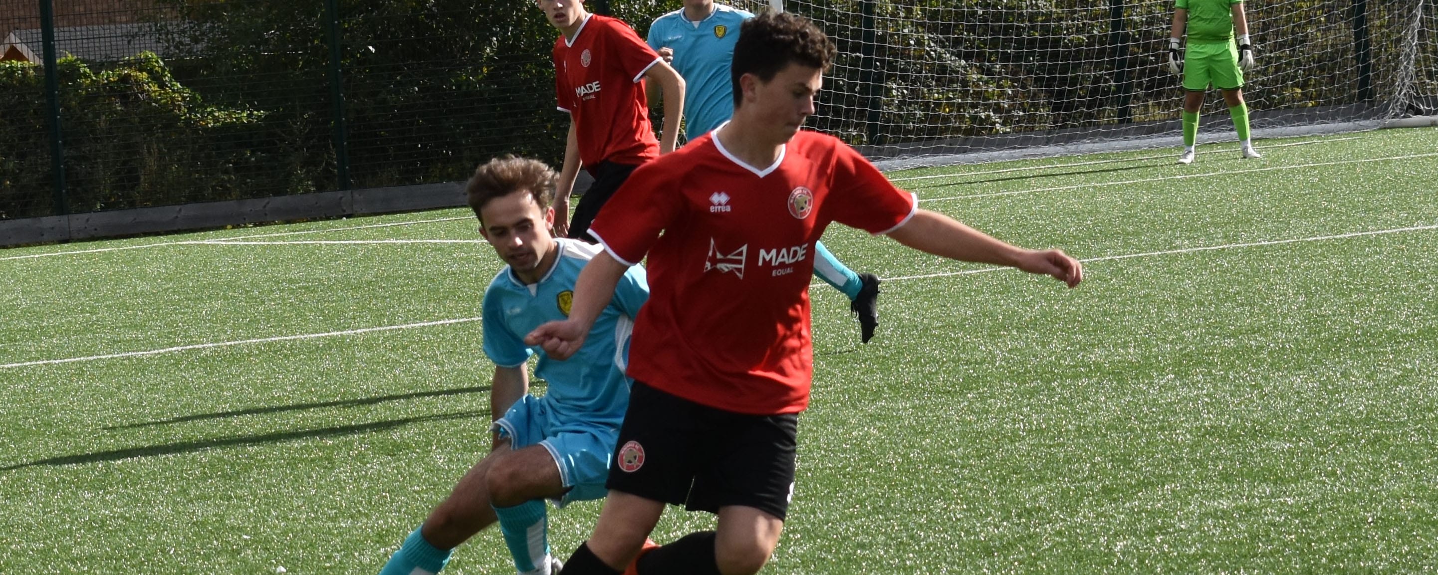 action shot football student tackles opponent on pitch