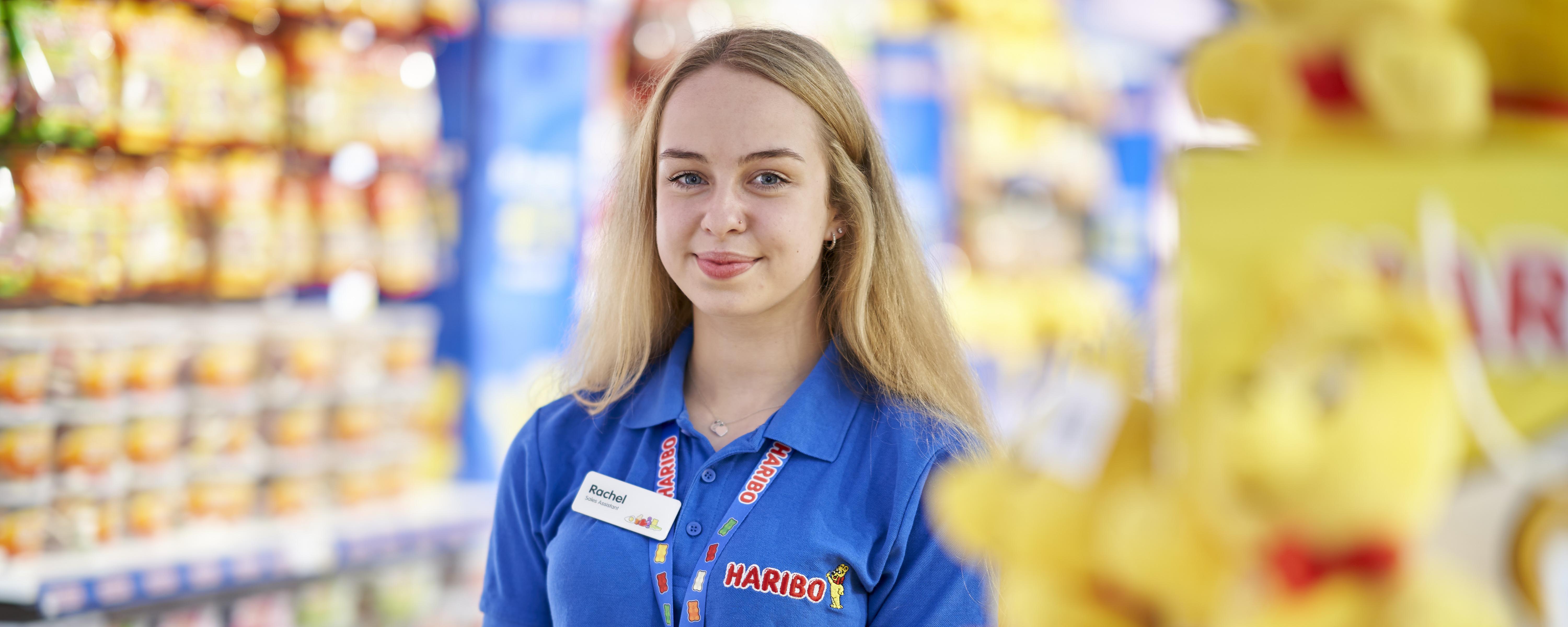 female retail assistant in sweet shop facing