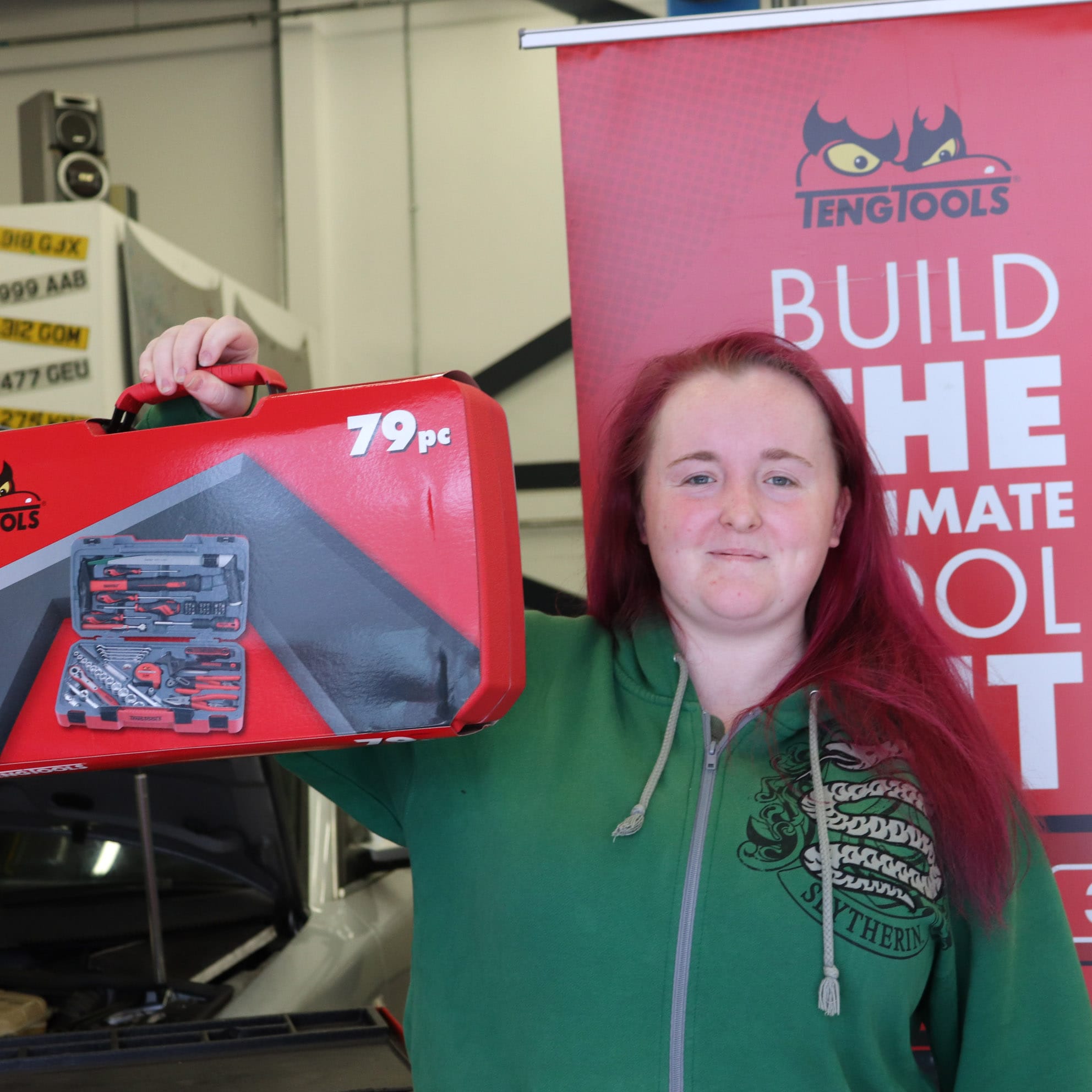 female automotive student holds aloft Teng Tools toolkit facing