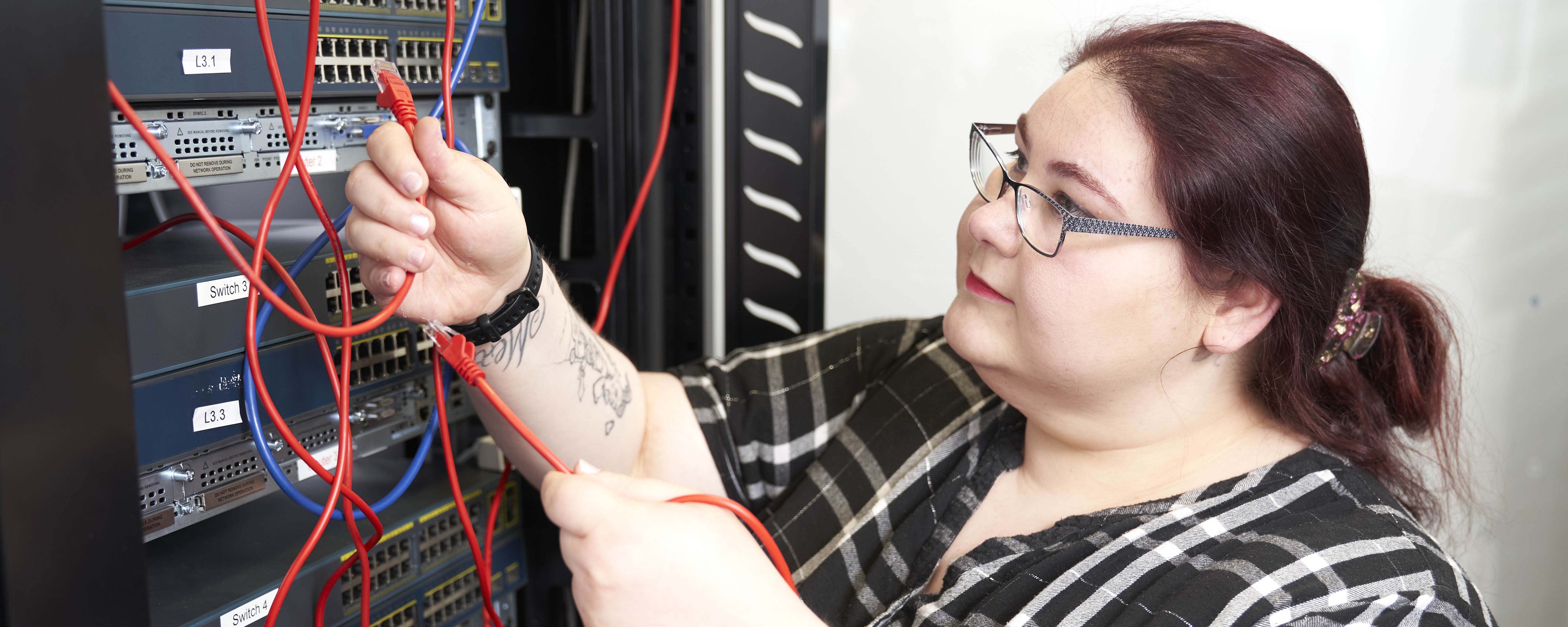 female adult computing student repairing hardware