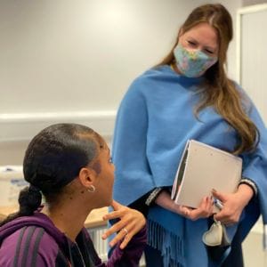 Ofqual representative speaks to female student in classroom