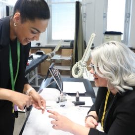 beauty student shows nail art to HD Professional Nail Systems representative