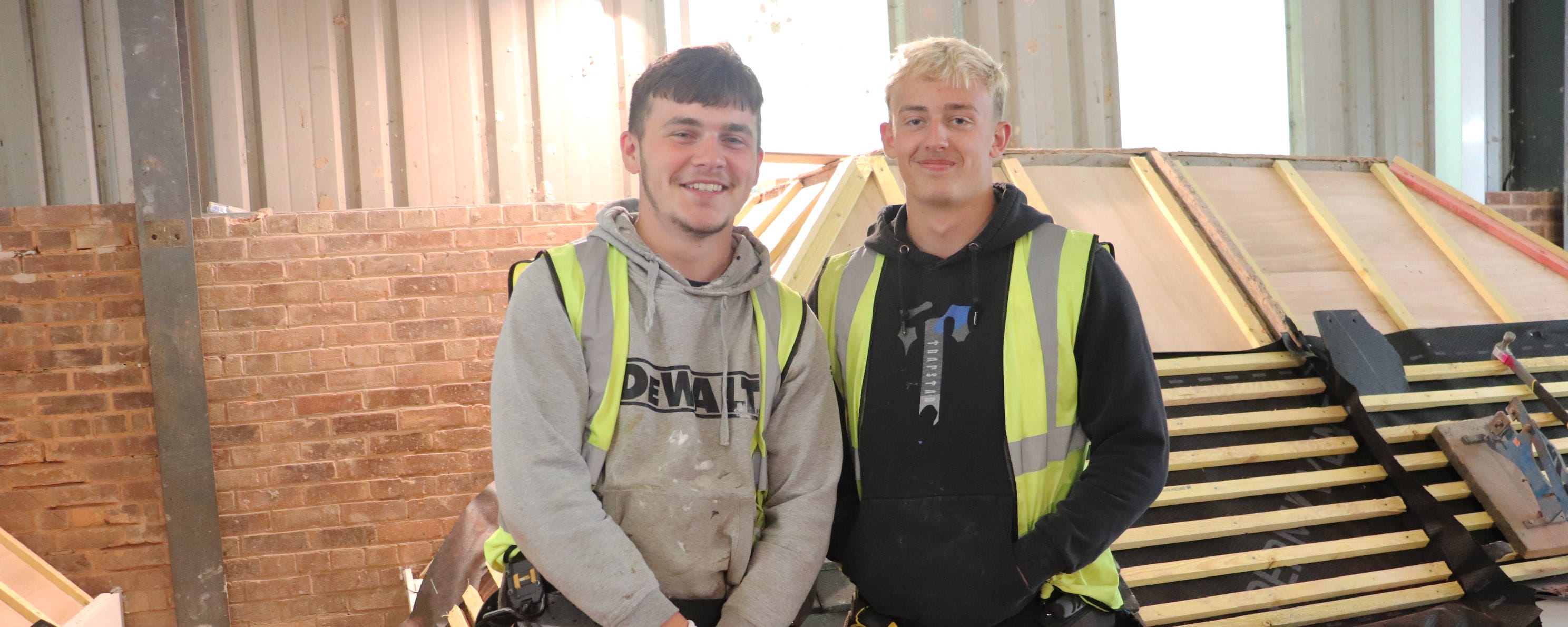 two roofing apprentices facing