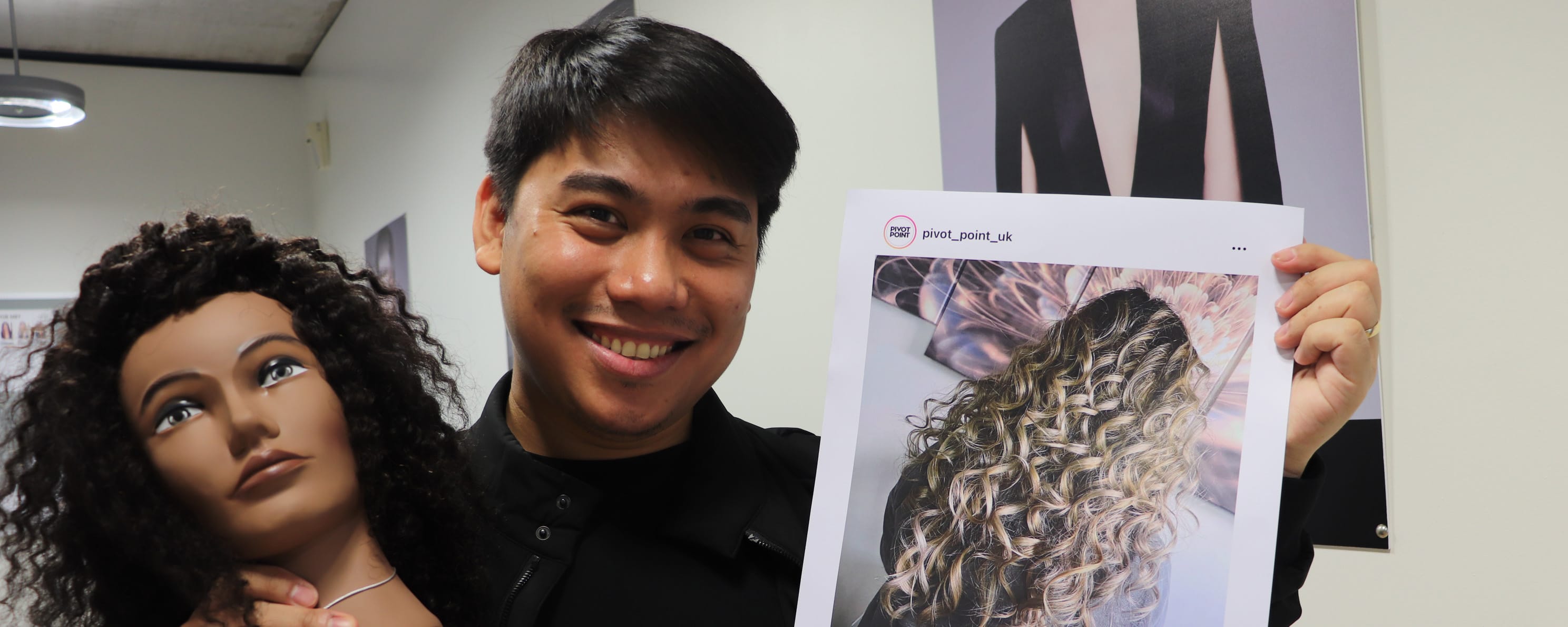male student hairdresser holding instagram post screenshot and mannequin prize