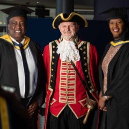 town crier with two higher education graduates
