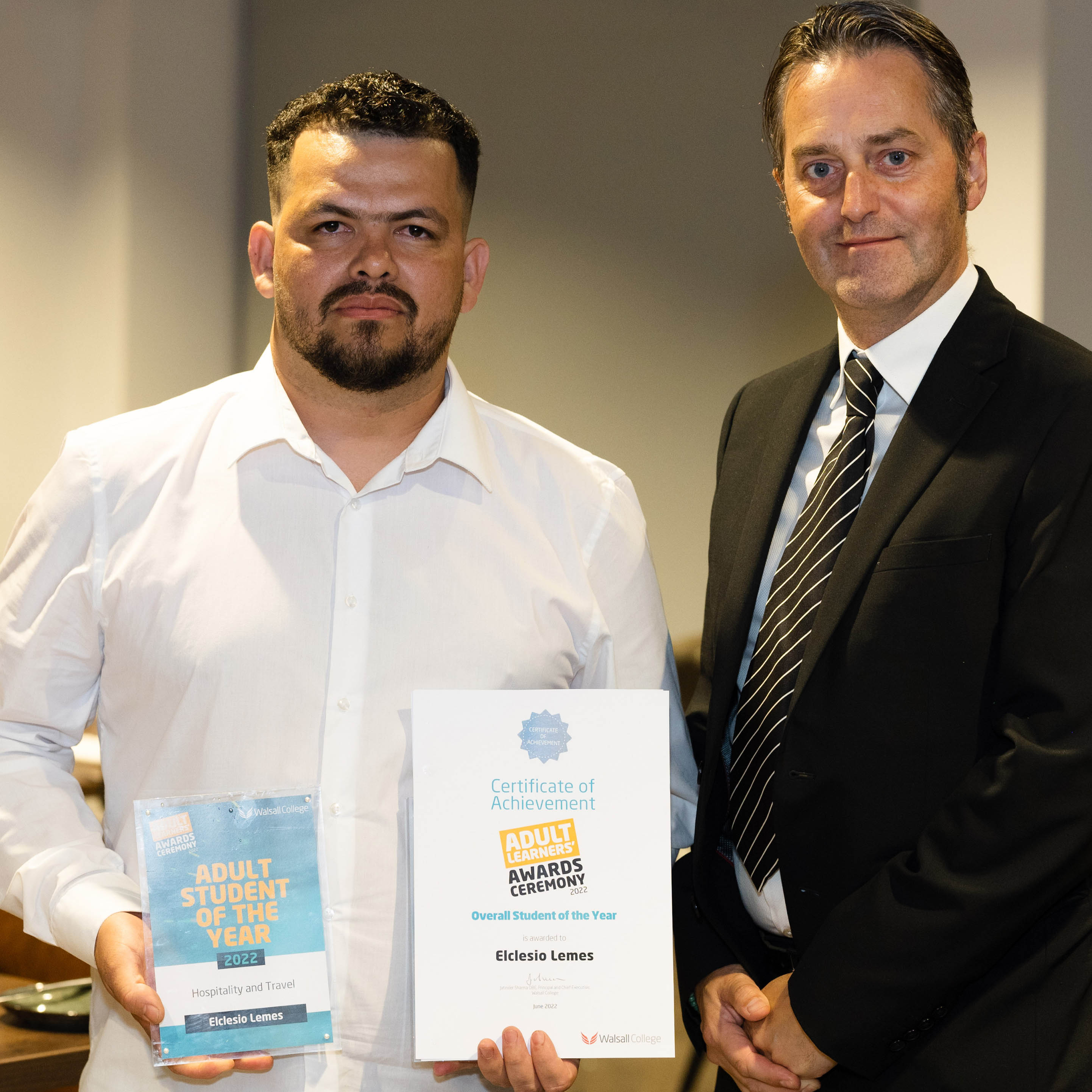 Adult student of the year poses with awards, with assistant principal