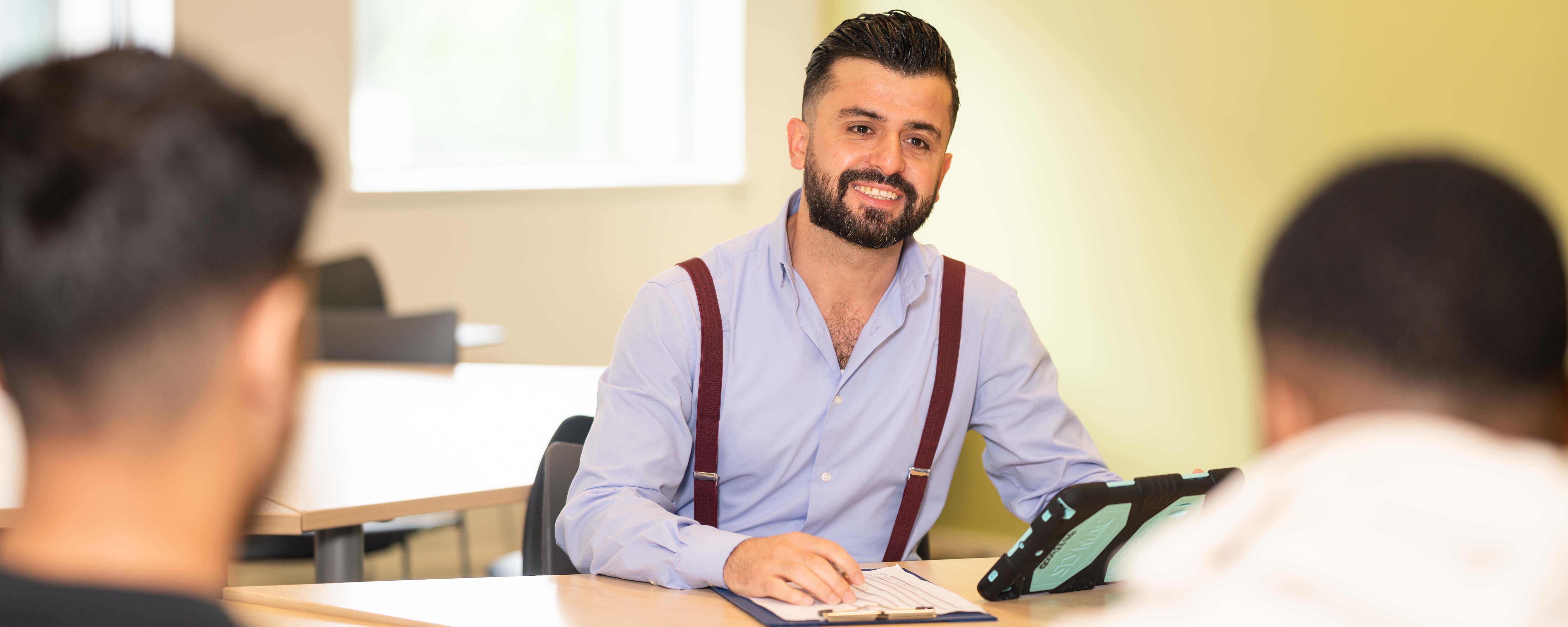 male adult learner as interpreter facing speaking to two people