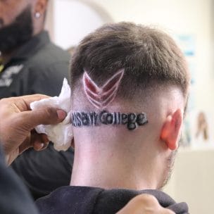 close-up walsall college logo shaved into model's head