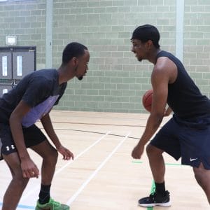 two basketballers face each other on court