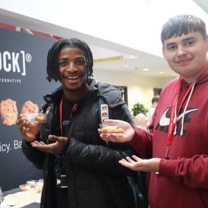 two students hold food samples