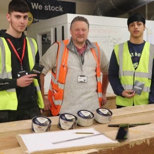 carpentry students and lecturer pose with stool and Liberon paste