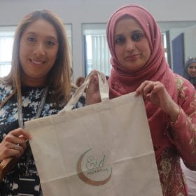 Lecturer and student pose with commemorative canvas bag