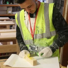 Painting and decorating student carries out repair technique 
