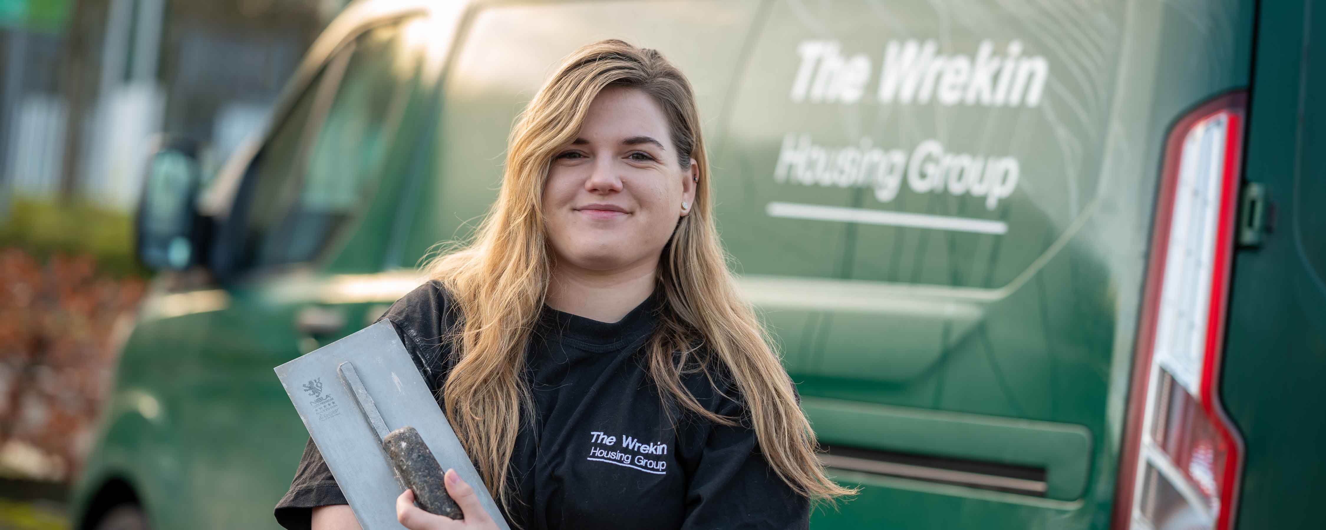 Trish Barnes poses by Wrekin van logo with award