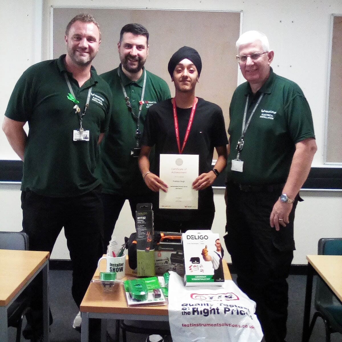  Two electrical installation faculty team members with student, Prabhjot facing. 