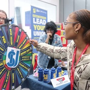 female student participates in spin wheel activity at Freshers Fair event