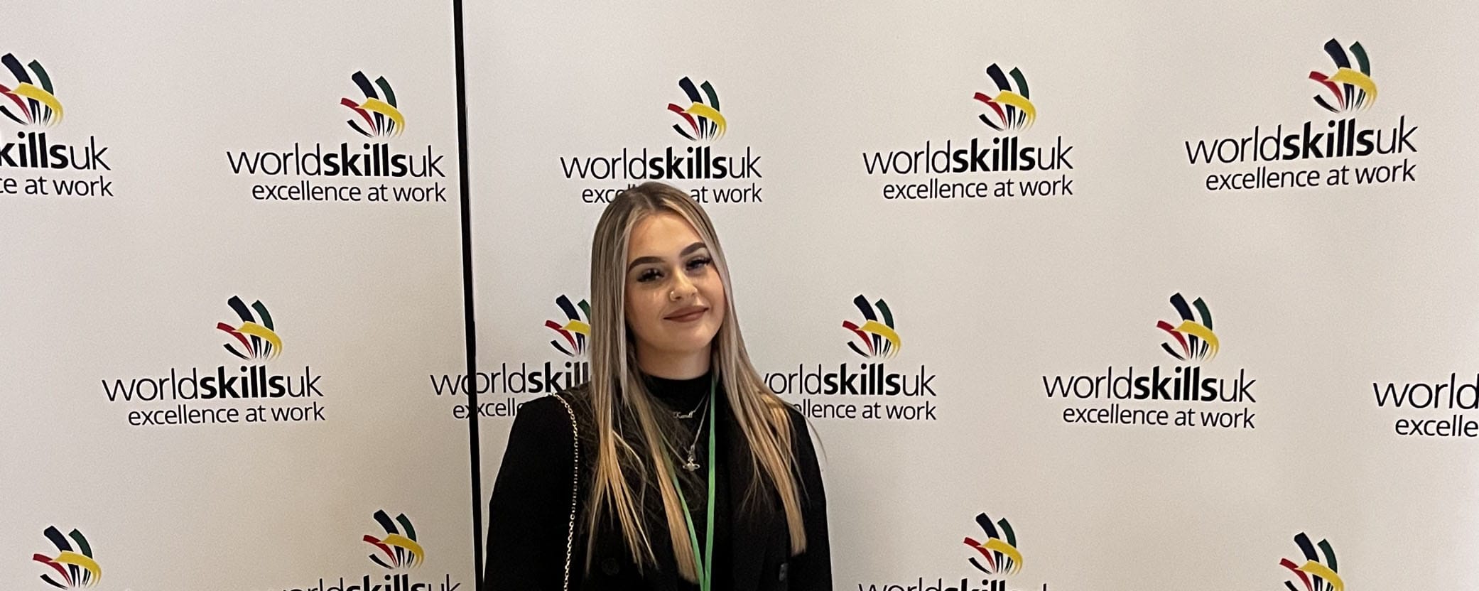 female student facing in front of WorldSkills backdrop