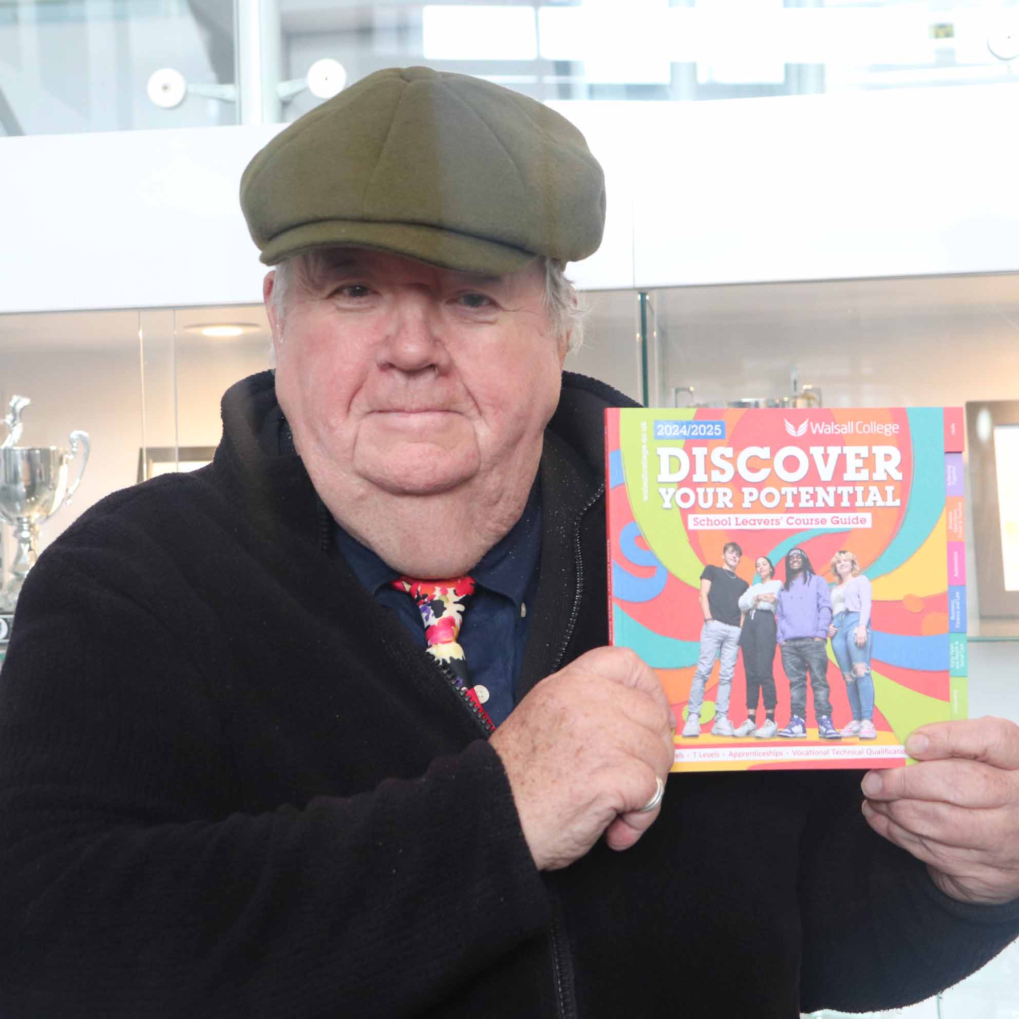 actor poses with college brochure facing