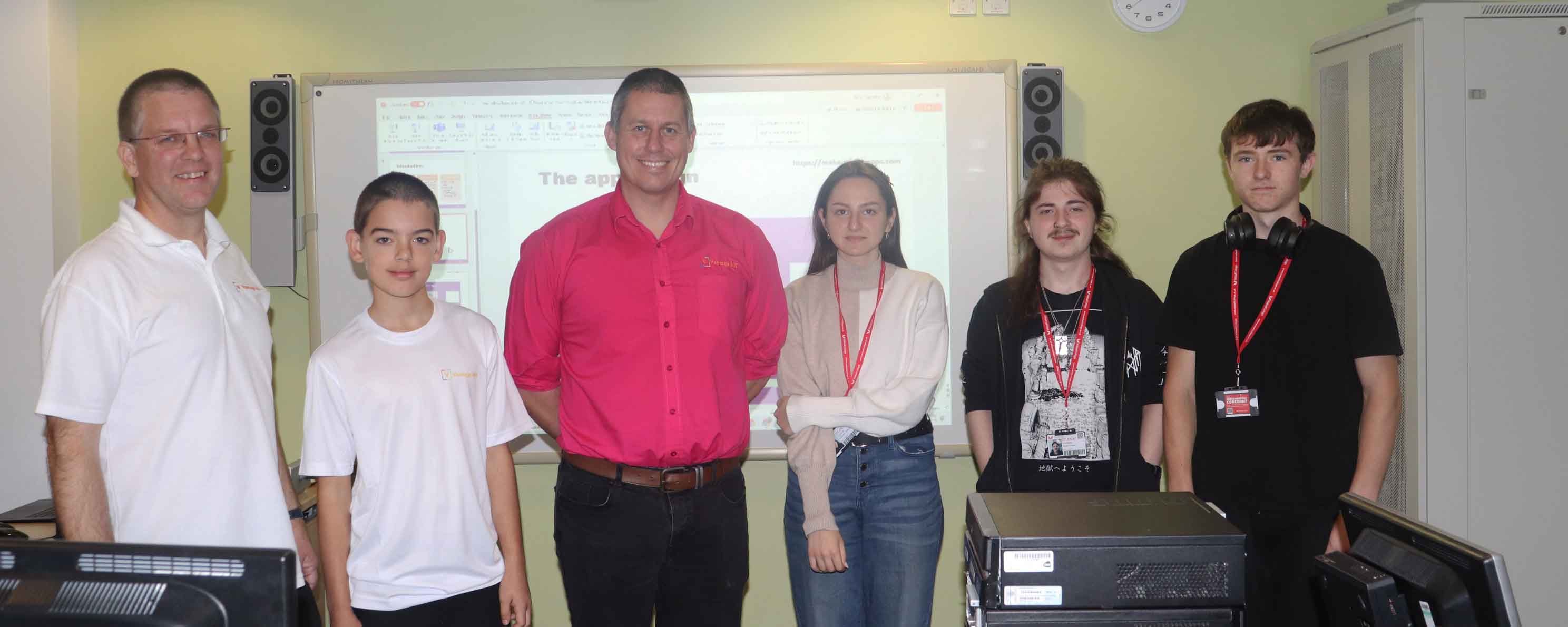 group shot of employers posing with students in front of whiteboard facing