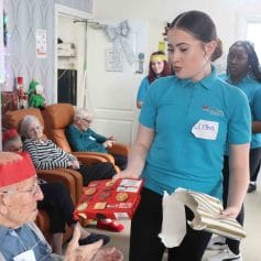 female student passes prize to care home resident