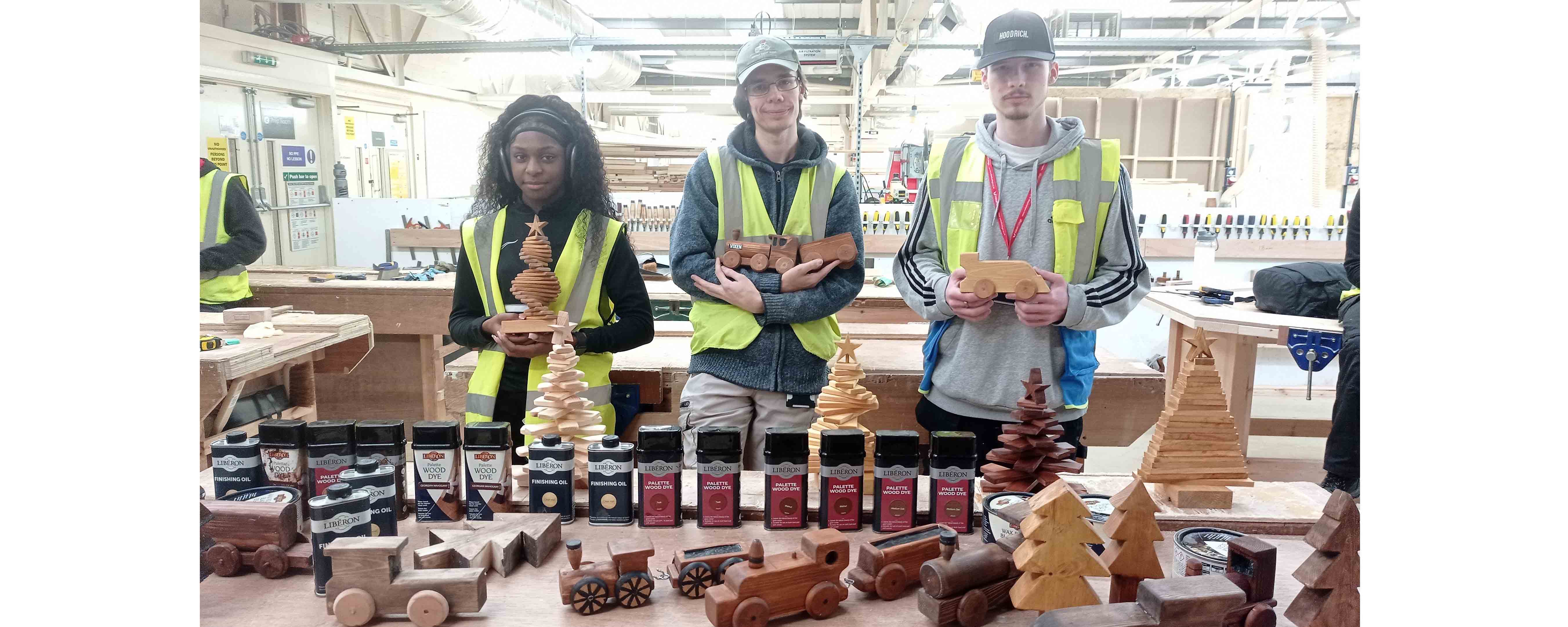 female and two male students posing with festive accessories and Liberon products