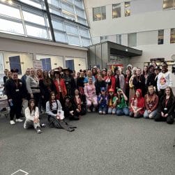 group shot of students and staff in literary costumes facing