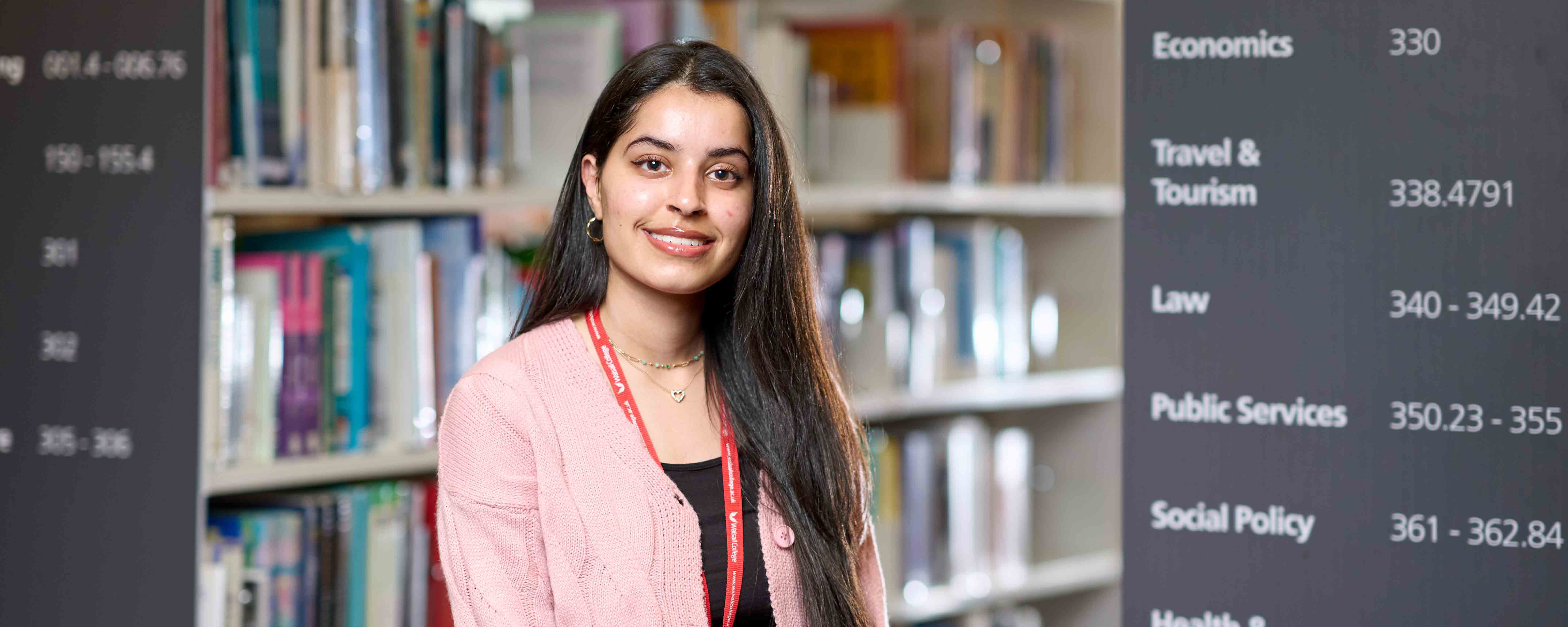 female student facing in front of library shelves