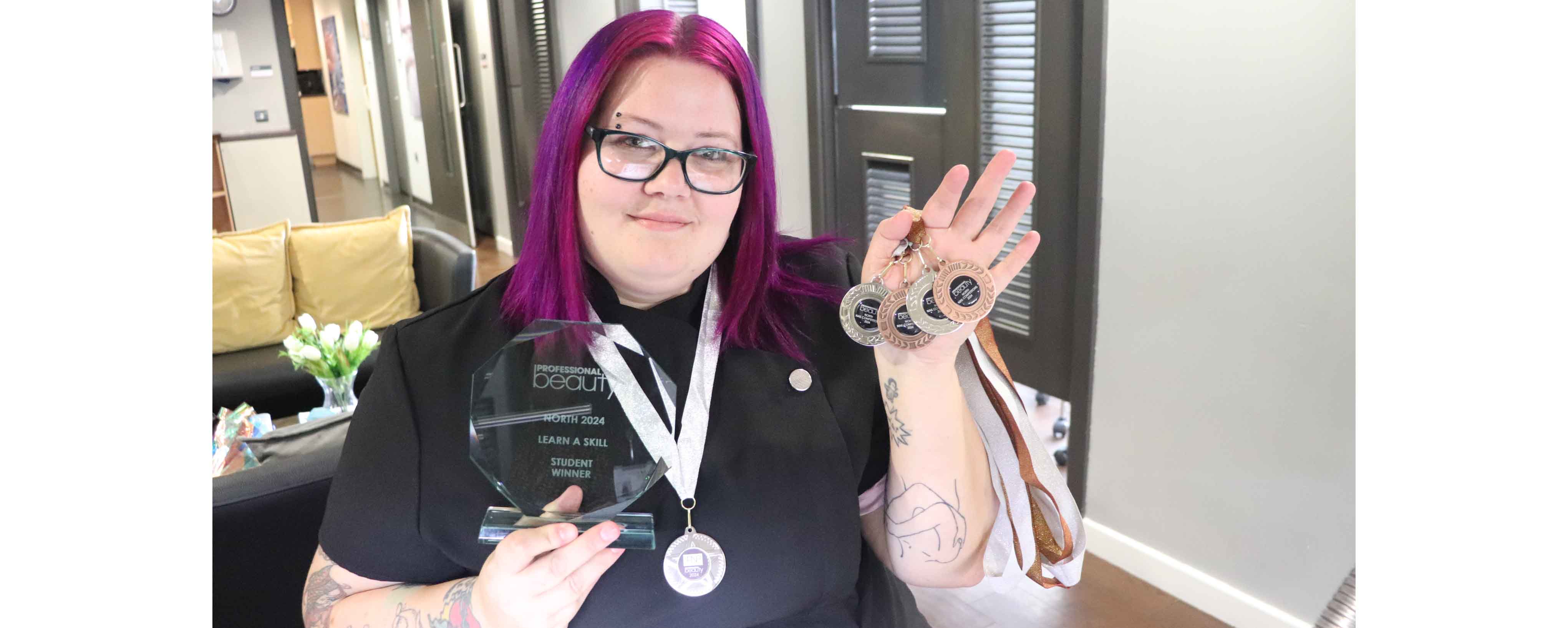 female holds up prize medals facing