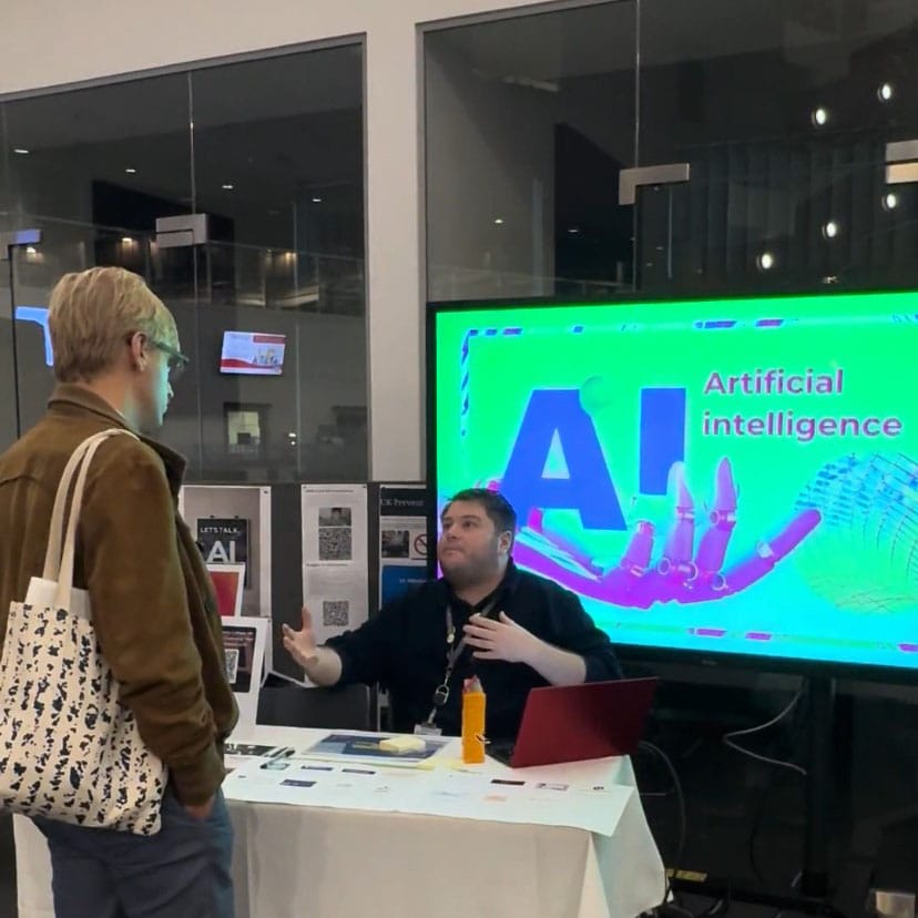 male at table speaking to another person