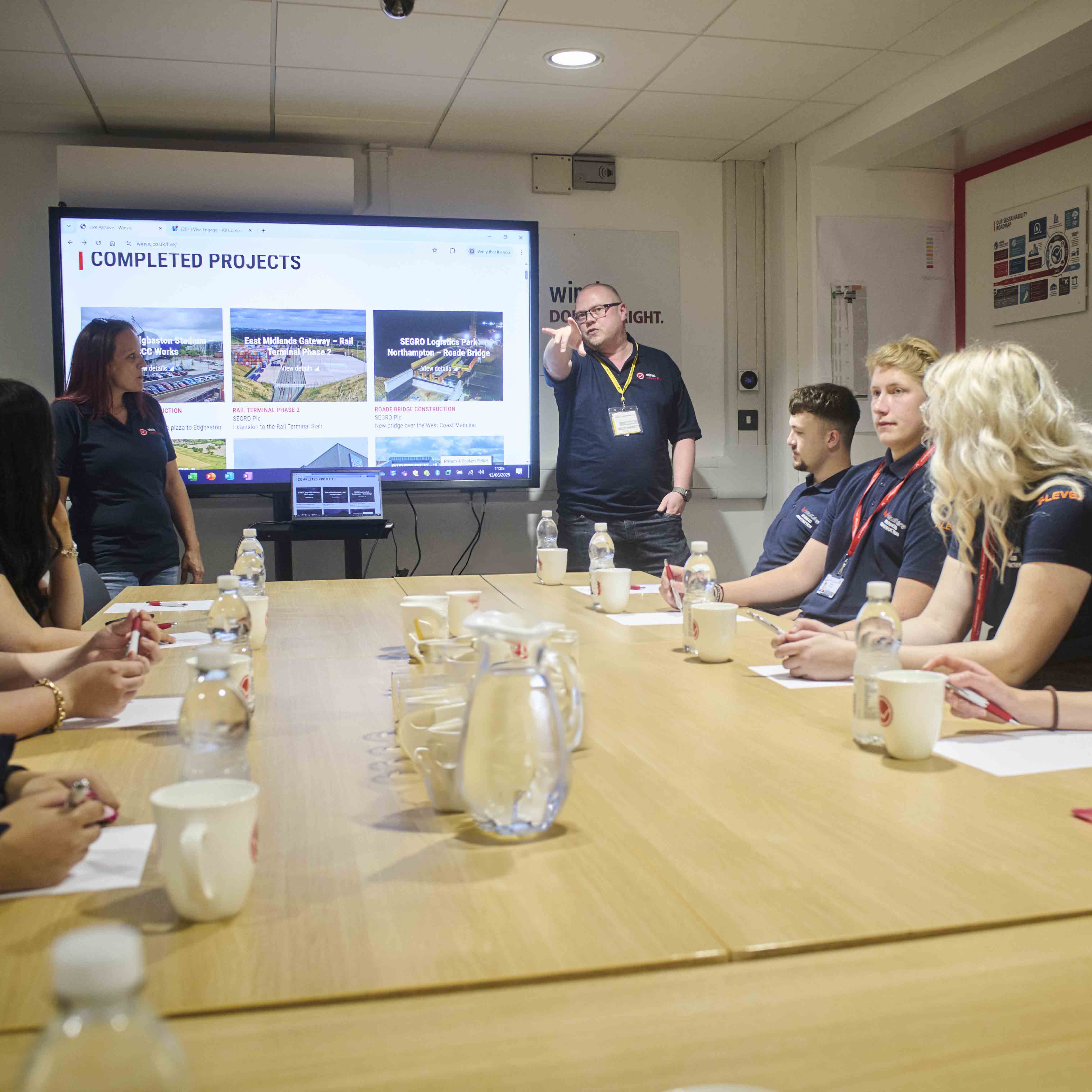 Winvic staff address students seated around a table