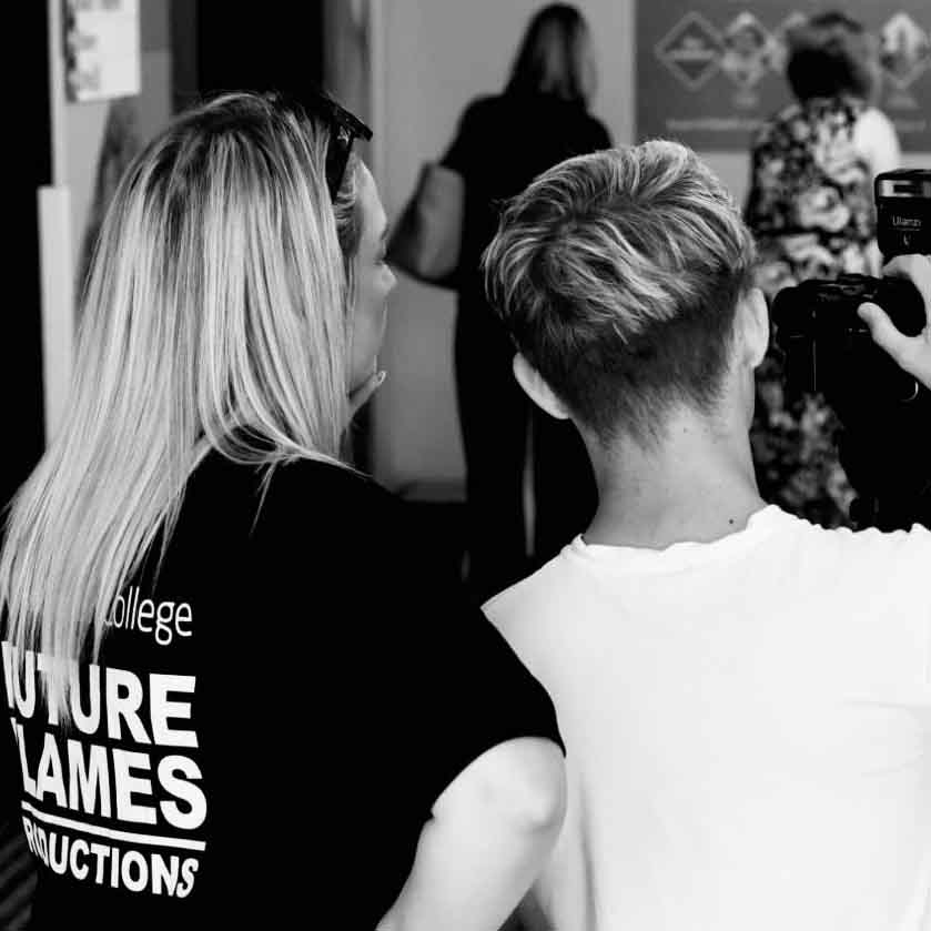 lecturer overseeing student cameraperson as they film - with backs to camera