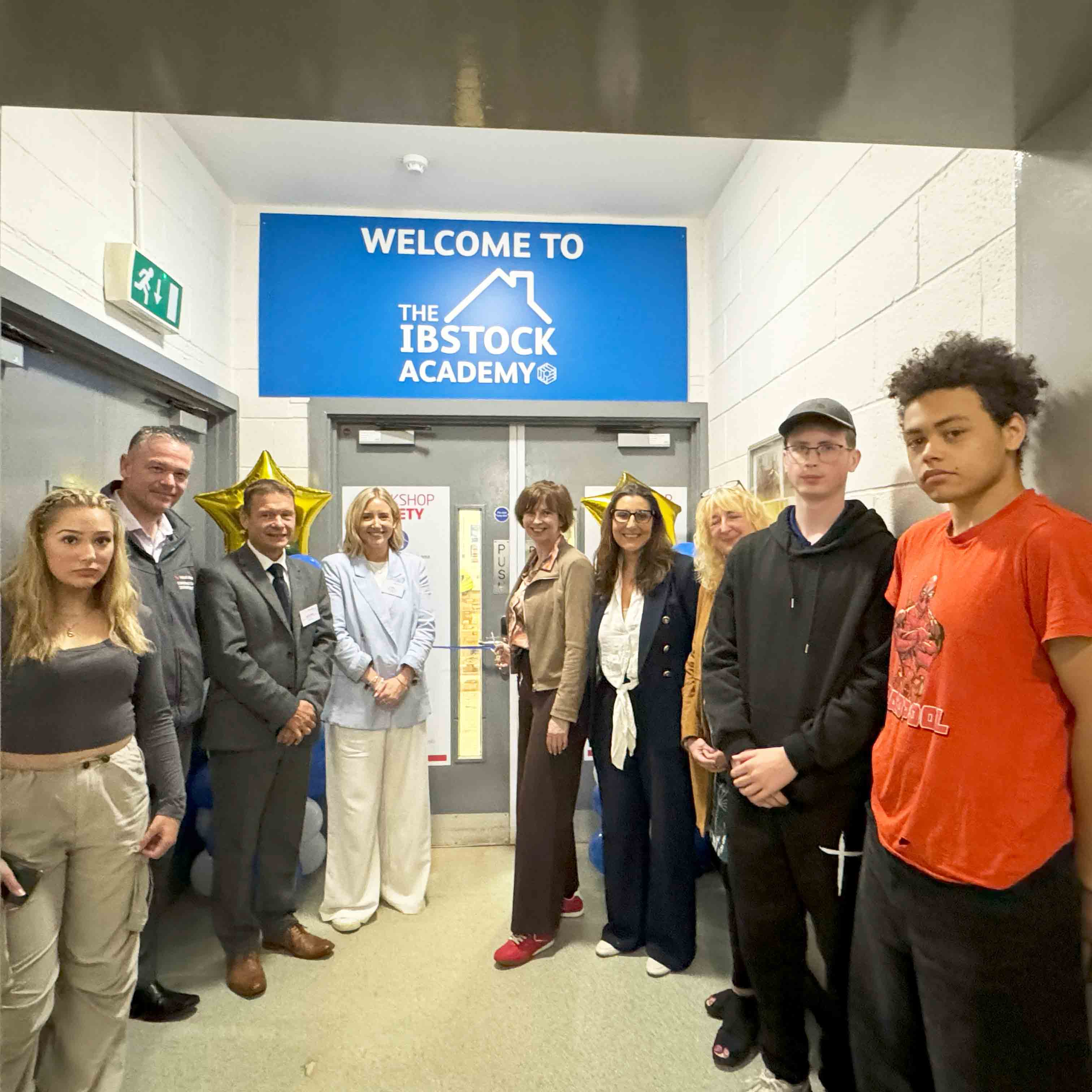 Students staff and partners pose outside new Academy