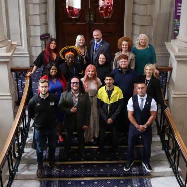 group of people pose  on stairs in town hall