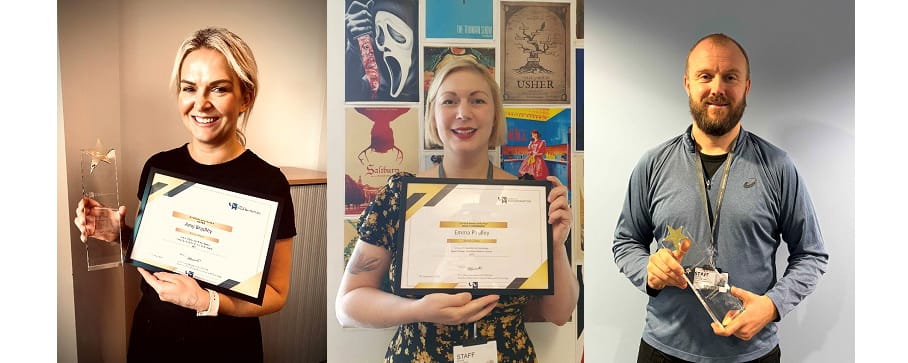 Three individuals posing with certificates and awards
