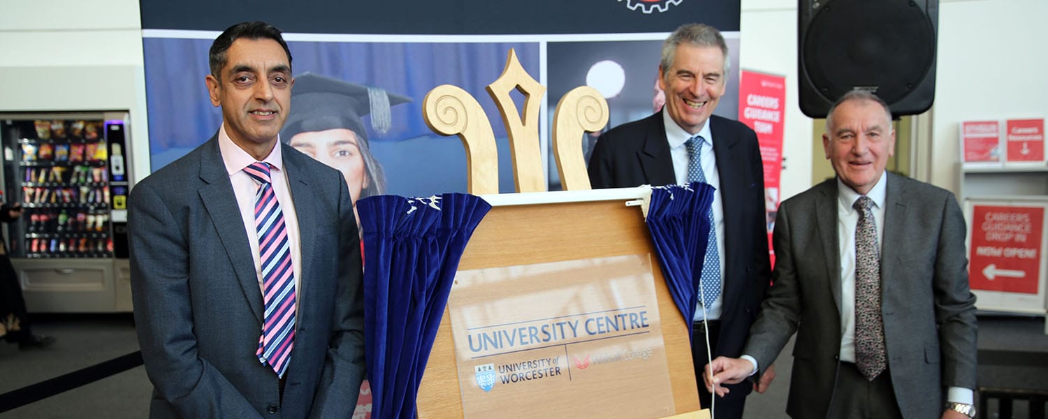 Three senior leaders posing next to unveiled plaque
