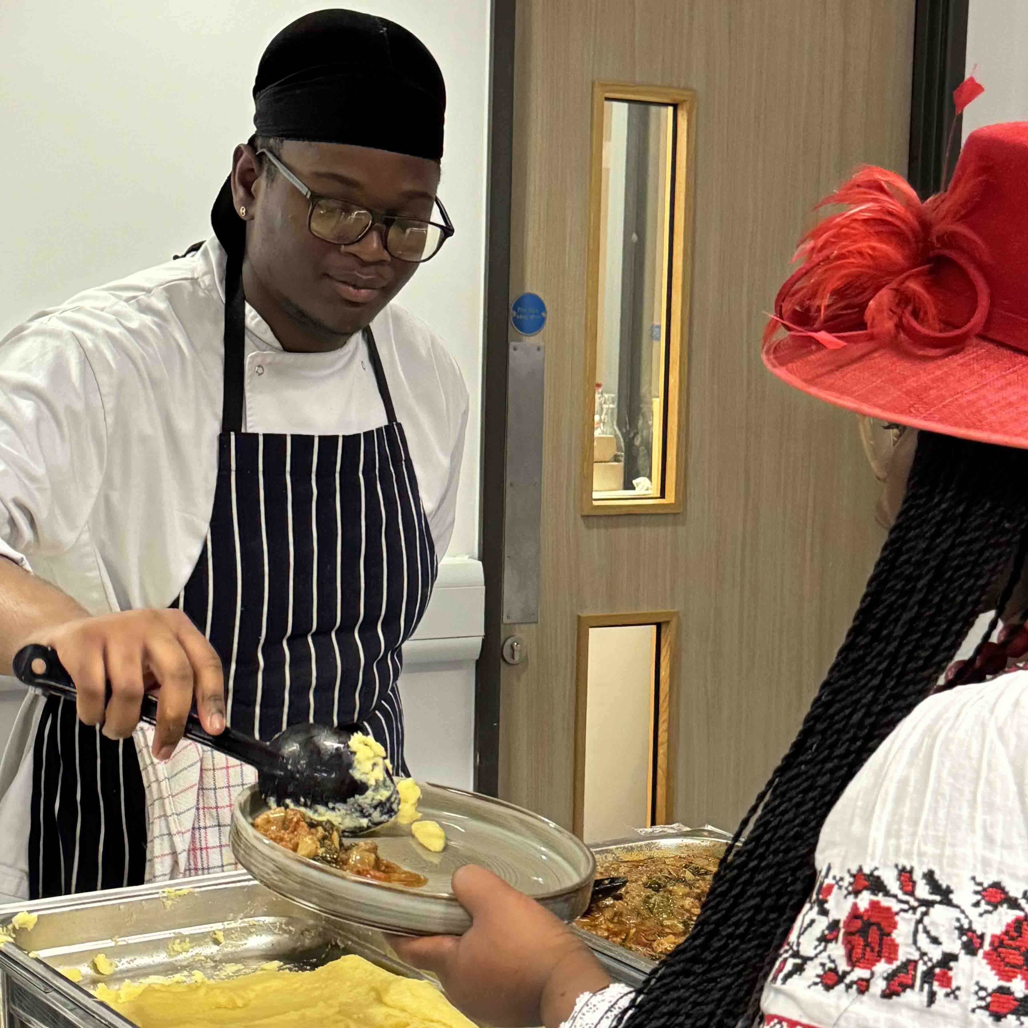 male student chef  facing serves food to guest