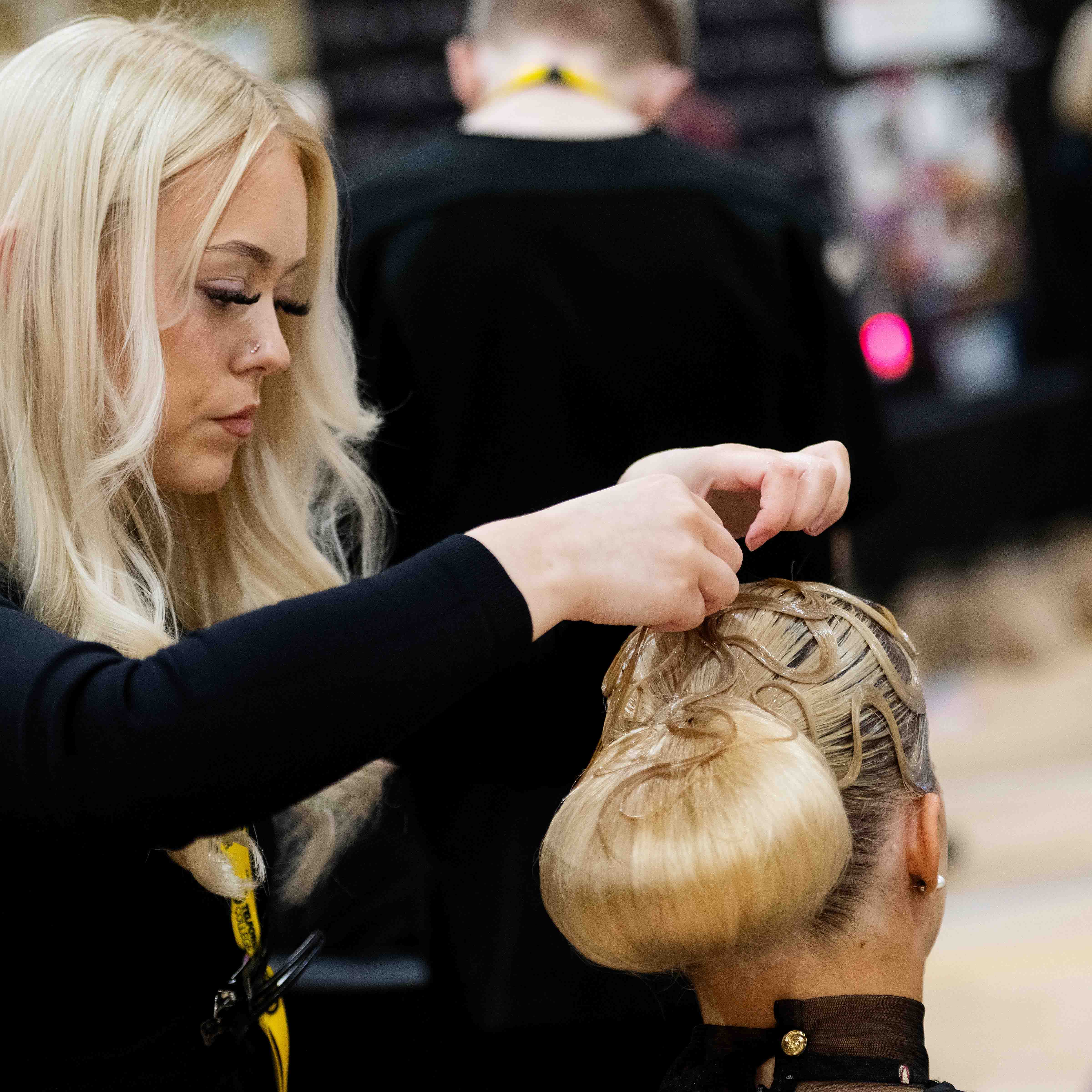 female hairdresser adjusts models hair